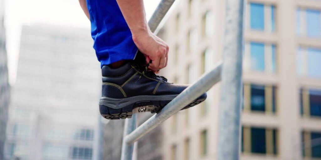 Construction worker tying his work boots
