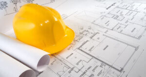Construction hat on top of plans