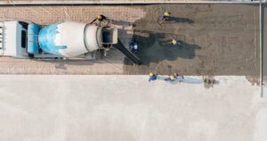 Aerial view a constuction worker pouring concrete road at construction site