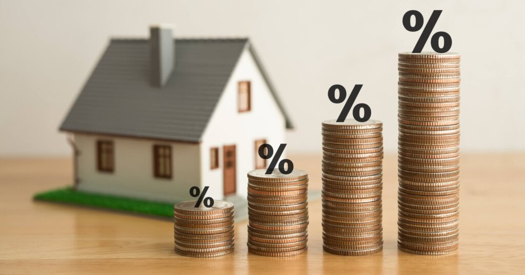 Stack coins as graph trend up and interest rates with house model background. FED fix recession inflation crisis by increase interest rate that effect to house buyer. Mortgage loan, financial concept.