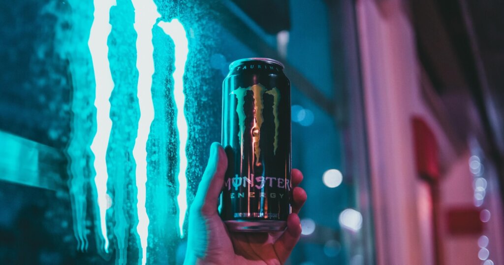 Monster energy drink held up in a person's hand