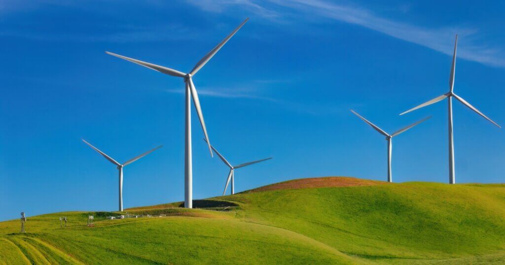 wind turbines on a green hill generating power