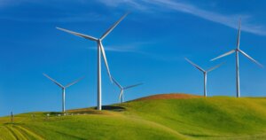 wind turbines on a green hill generating power