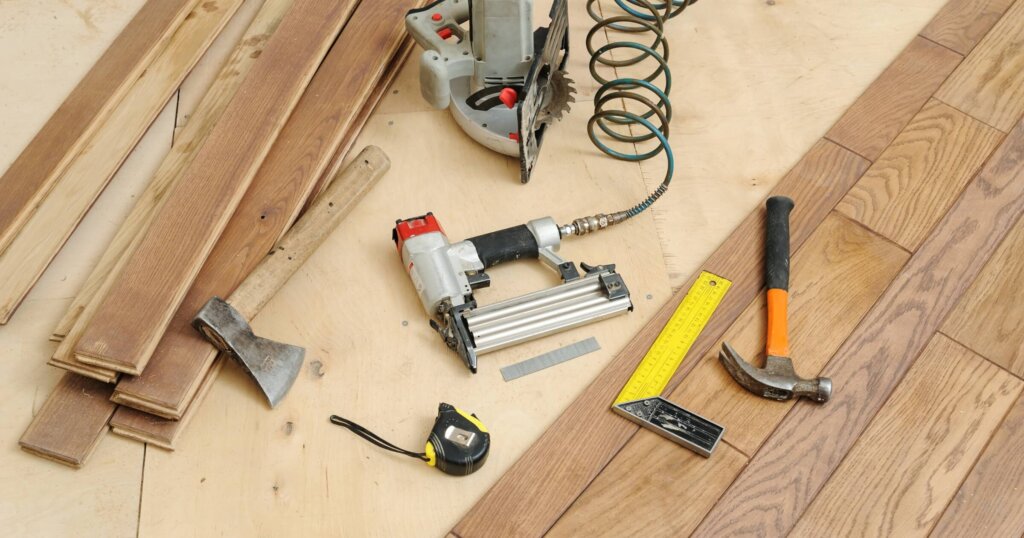 Installing a wooden floor. Carpenter's tools on the floor.
