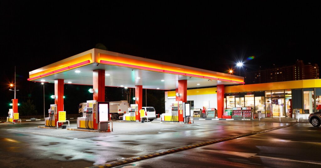 Petrol gas station station at night with lights on and mini-mart
