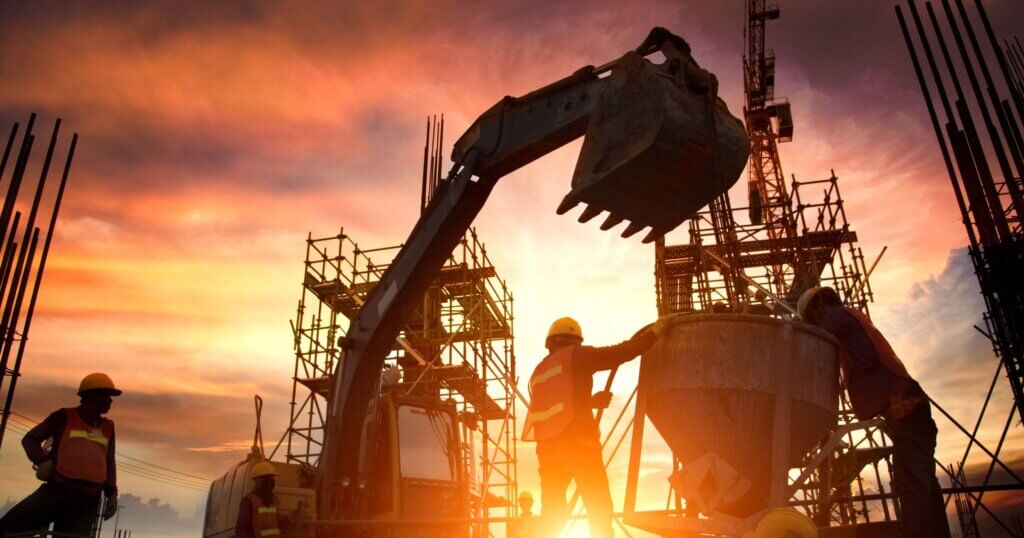 Silhouette Teams of Business Engineers looking for blueprints in construction sites through blurry construction sites at sunset.