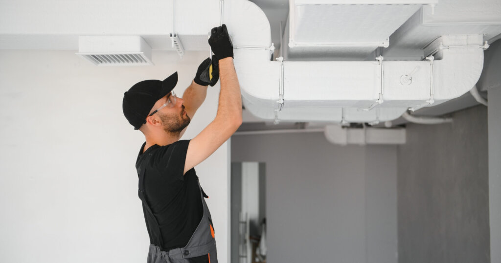 hvac services, worker install ducted pipe system for ventilation and air conditioning in house.