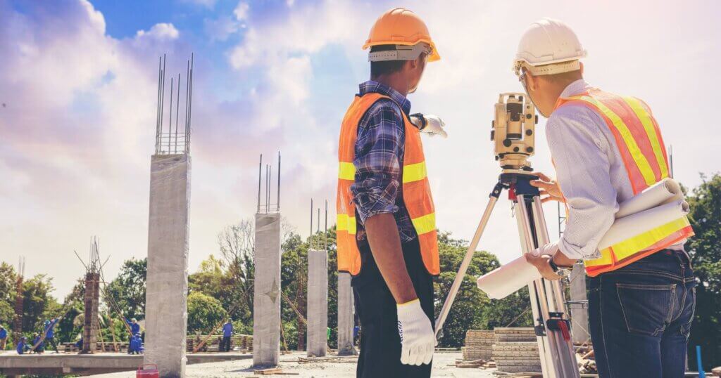 Engineer or surveyor worker working with theodolite transit equipment at outdoors construction site. Selected focus