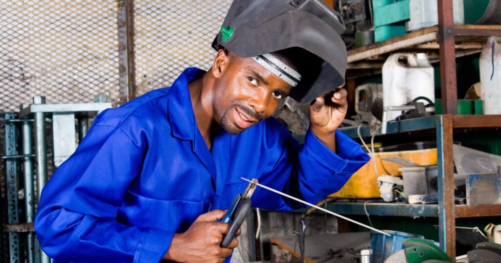 african male welder with welding equipment.
