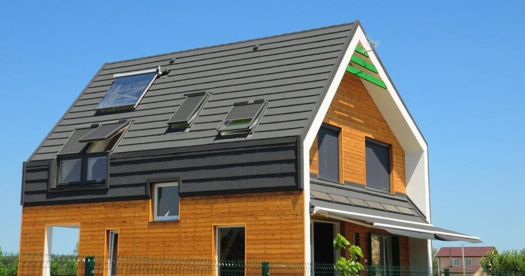 Modern wooden passive house with solar water heating systems. Attic skylights, dormer, ventilation with sun blinds for energy efficiency.