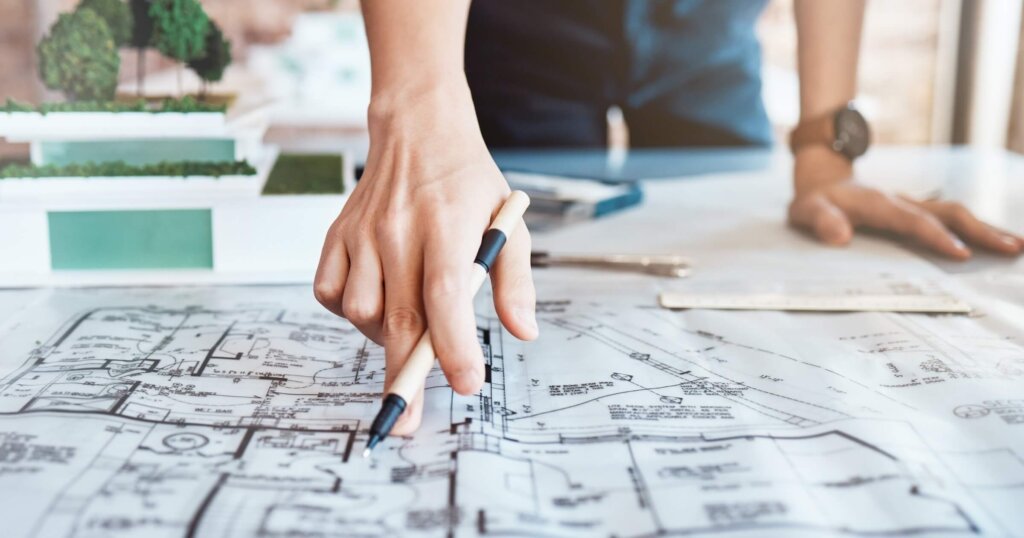 Architect, hand and blueprint on paper in office with property design, planning and pencil for review. Person, drawing and sketch with document, engineering and floor plan in workplace closeup.