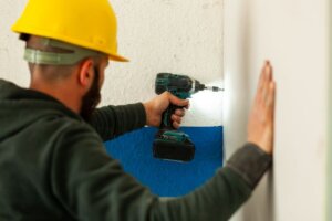 Construction worker with impact gun drilling