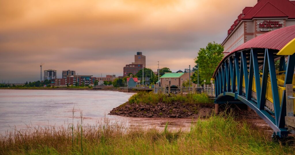 Moncton, New Brunswick, Canada - September 6 2023: city skyline, Petitcodiack River, pedestrian bridge, colourful dramatic sky