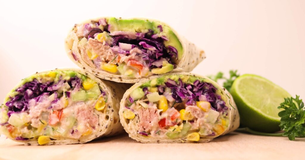 Tuna avocado wraps on a table with lime.