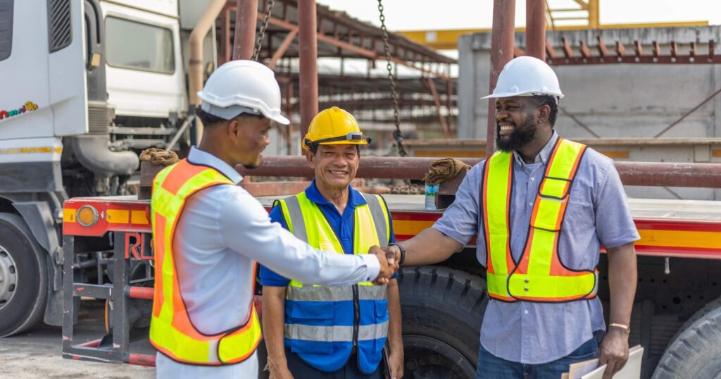 Two civil engineers or managers from different races come to agree on a manufacturing plan at a construction site. Cooperation between two civil engineering experts. Two workers have a handshake.