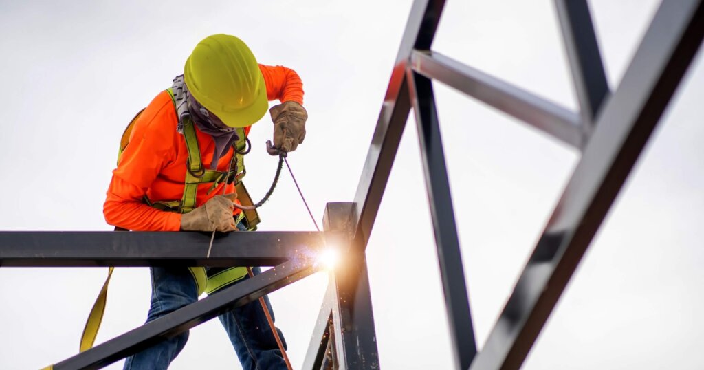 Ironworkers put on safety gear to work on the way to install the factory roof welding structure.