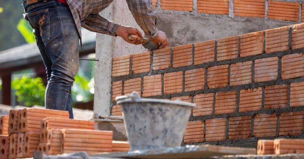Red bricks and mason are building bricks to build the walls of the building. Working requires professional skills. A balanced mix of mortar and leveled bricks.