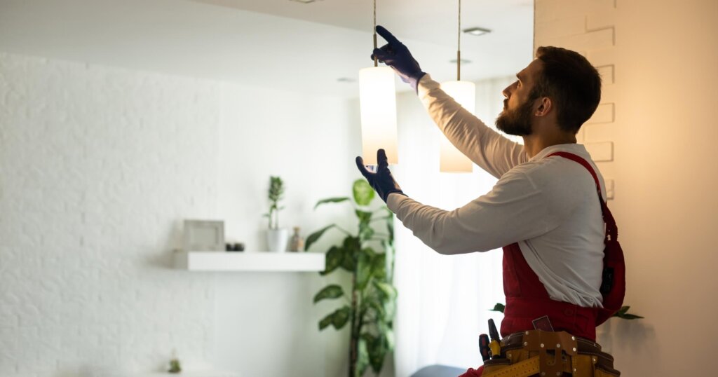 electrician installing led light bulbs in ceiling lamp