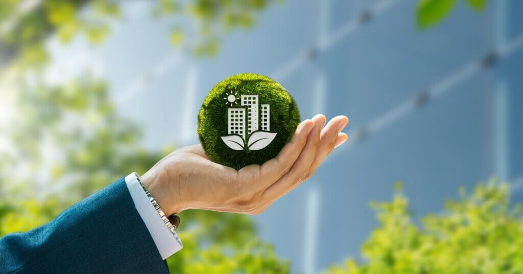 sustainable green building environmentally friendly buildings. Businessman holding green ball with white building shape.