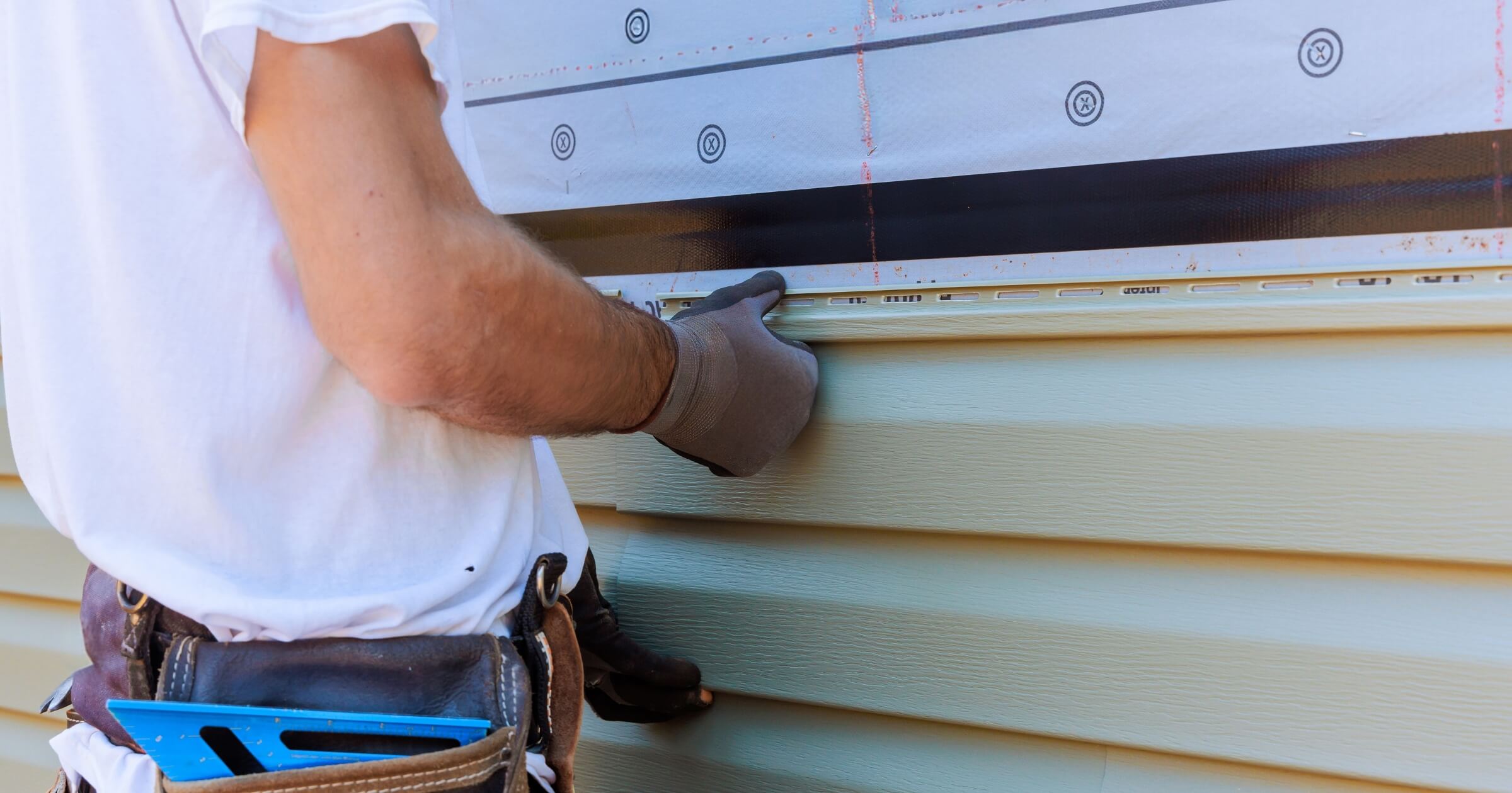 Handyman process installing vinyl PVC siding during construction on facade new home