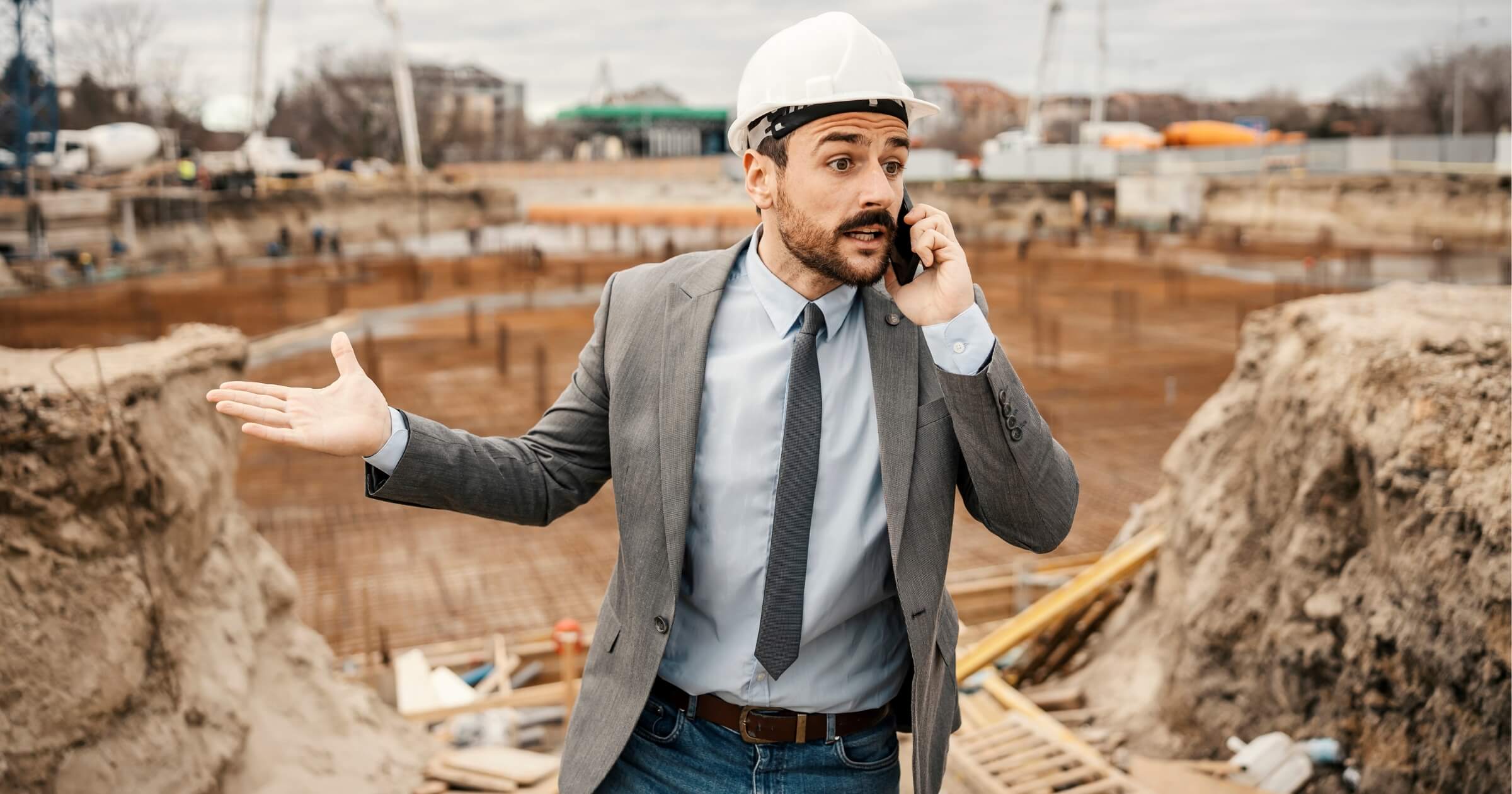 An angry architect is speaking on the phone with constructors and arguing about delay.