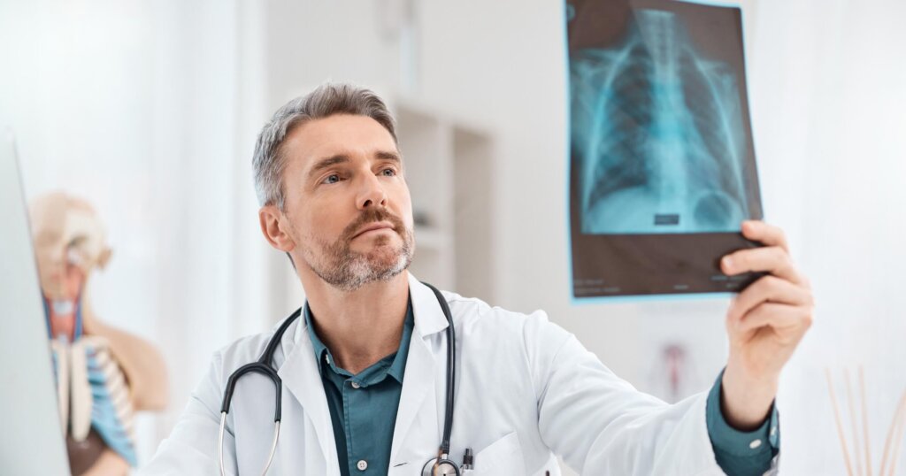 Shot of a mature doctor analysing x-ray scans in a medical office.