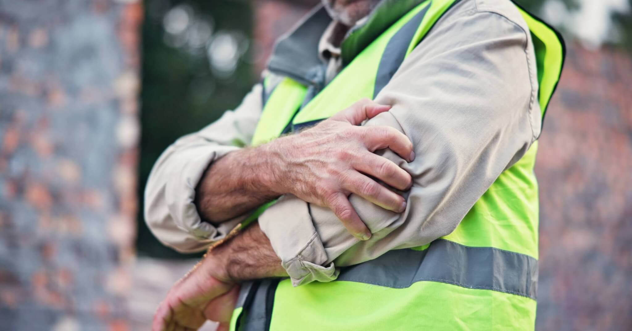 Hands, person and elbow pain with construction injury, work site accident or sprain with agony outdoor.