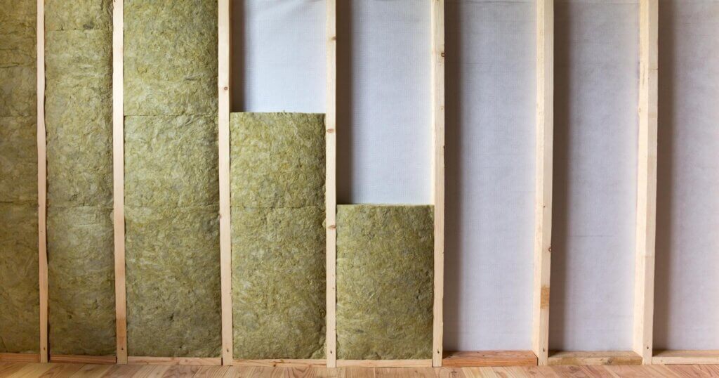 Wooden frame for future walls insulated with rock wool and fiberglass insulation staff for cold barrier. Comfortable warm home, economy, construction and renovation concept.