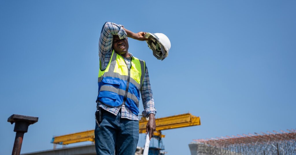 Tired Construction Worker Wiping Sweat Under the Hot Sun.