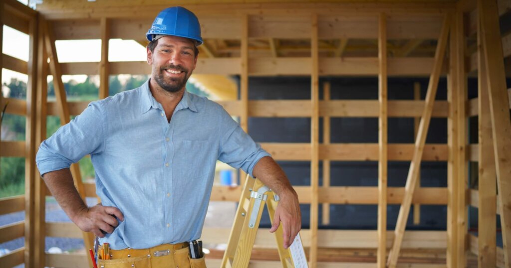 Portrait of construction worker smiling and looking at camera, diy eco-friendly homes concept.