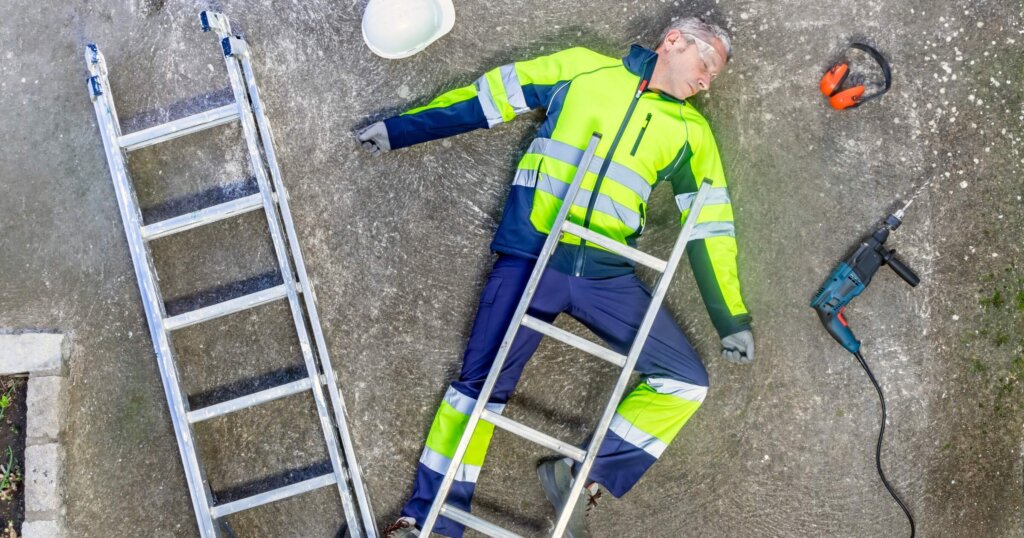 Unconscious construction worker lying on the ground after work accident.
