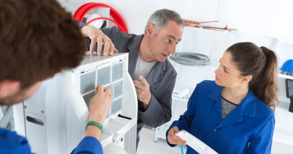 hvac apprentice working on commercial heating air conditioning unit