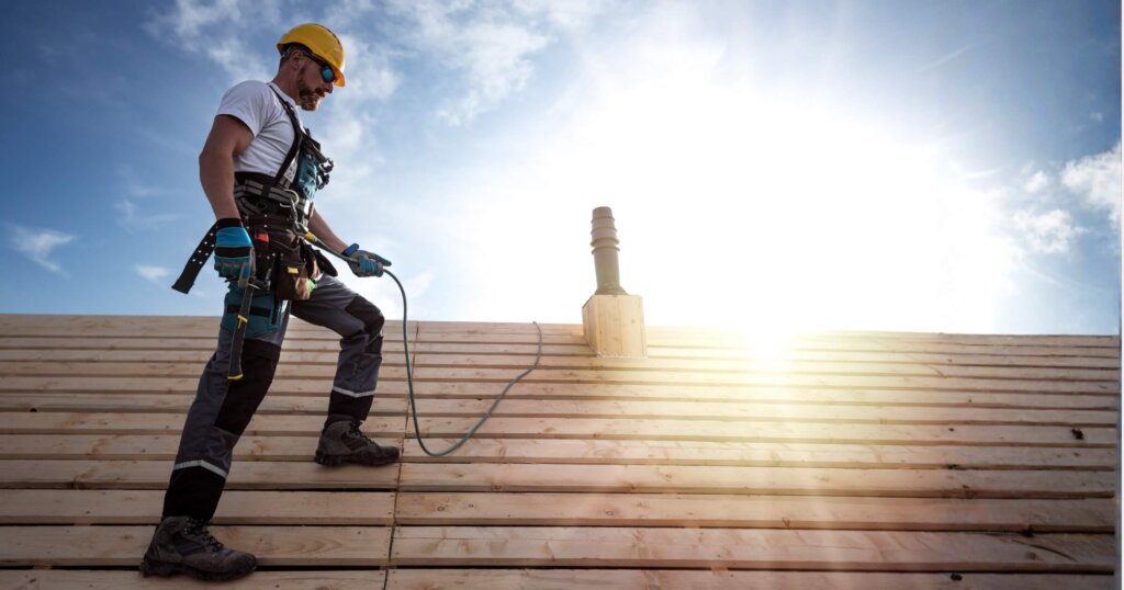 A roofer with a safety harness