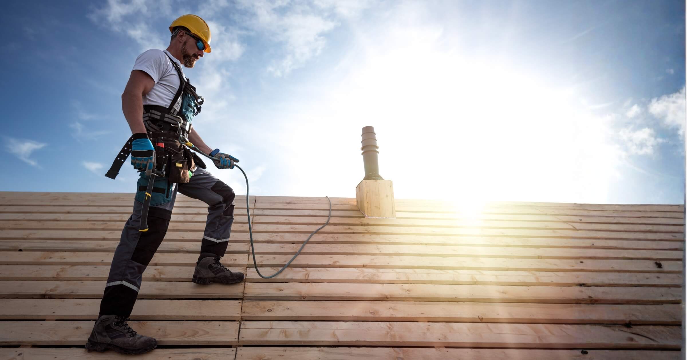 A roofer with a safety harness