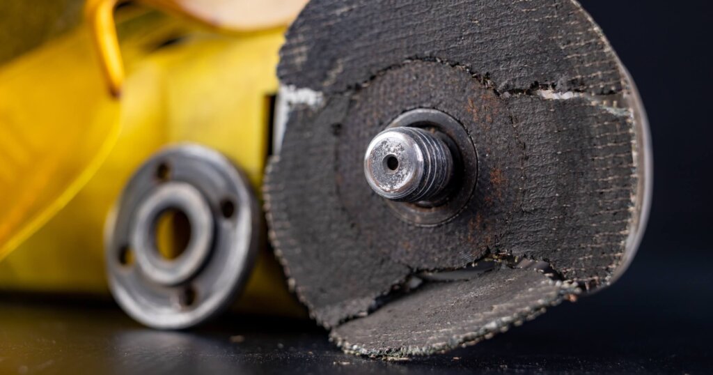 Damaged cutting disc for metal in an angle grinder power tool.