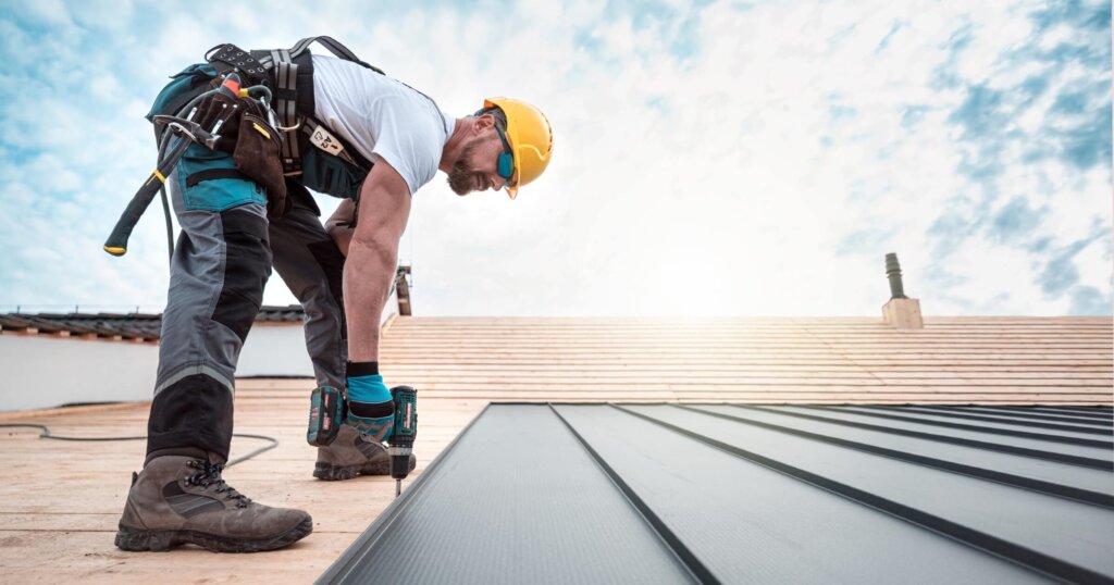 roofer with a safety harness and tool belt is working