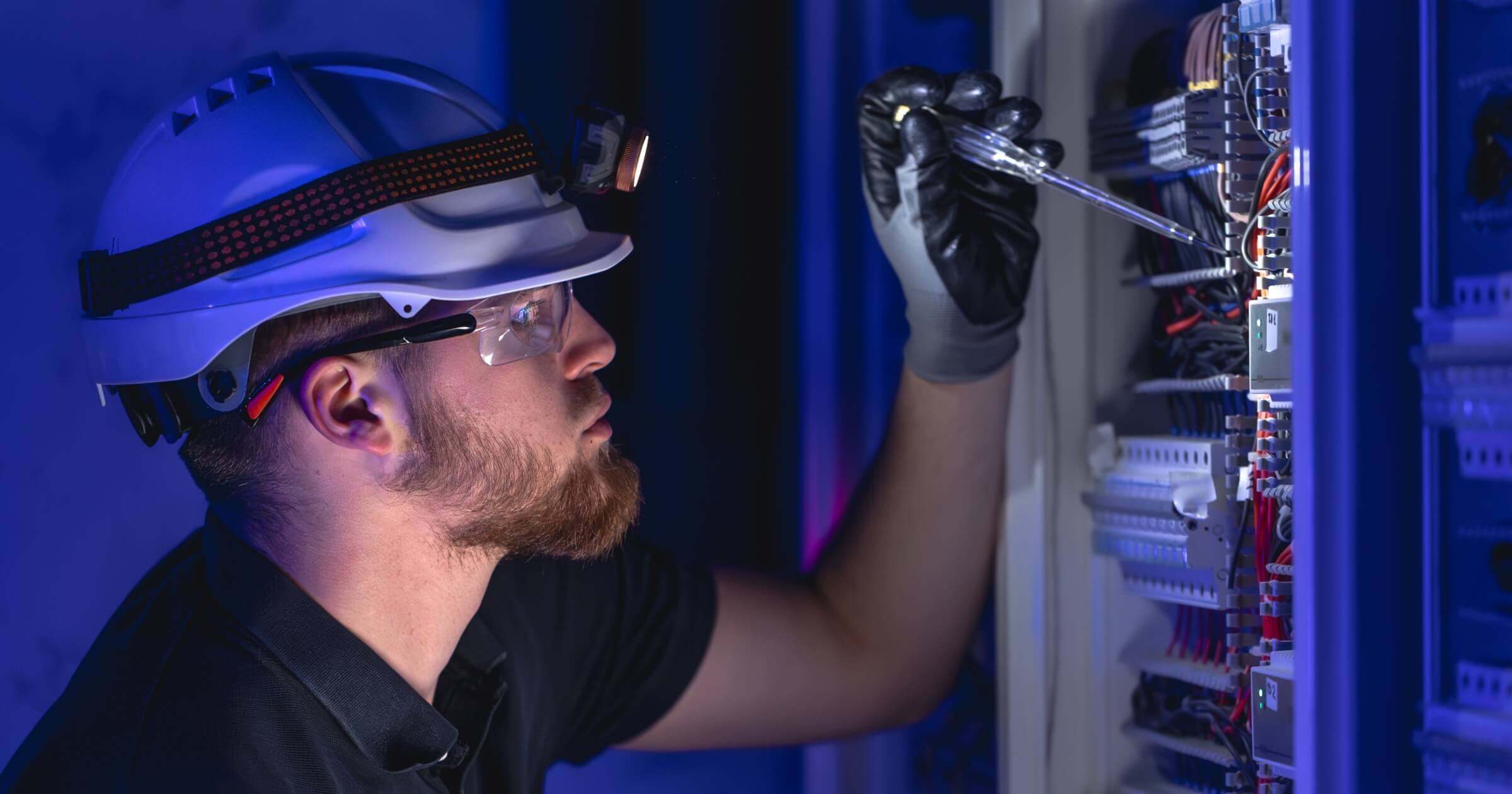 male electrician works in a switchboard