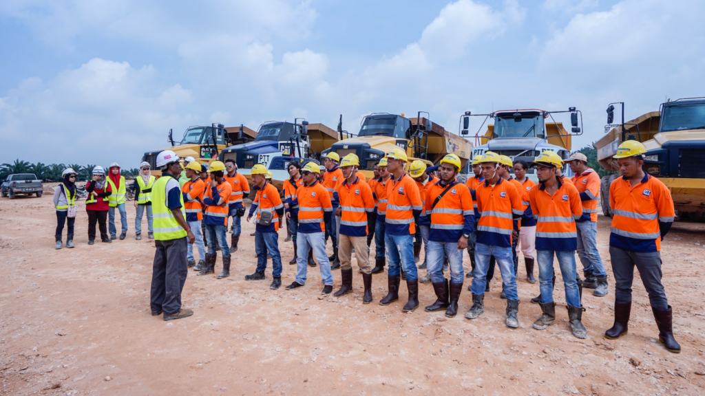Workers on construction site attending safety briefing