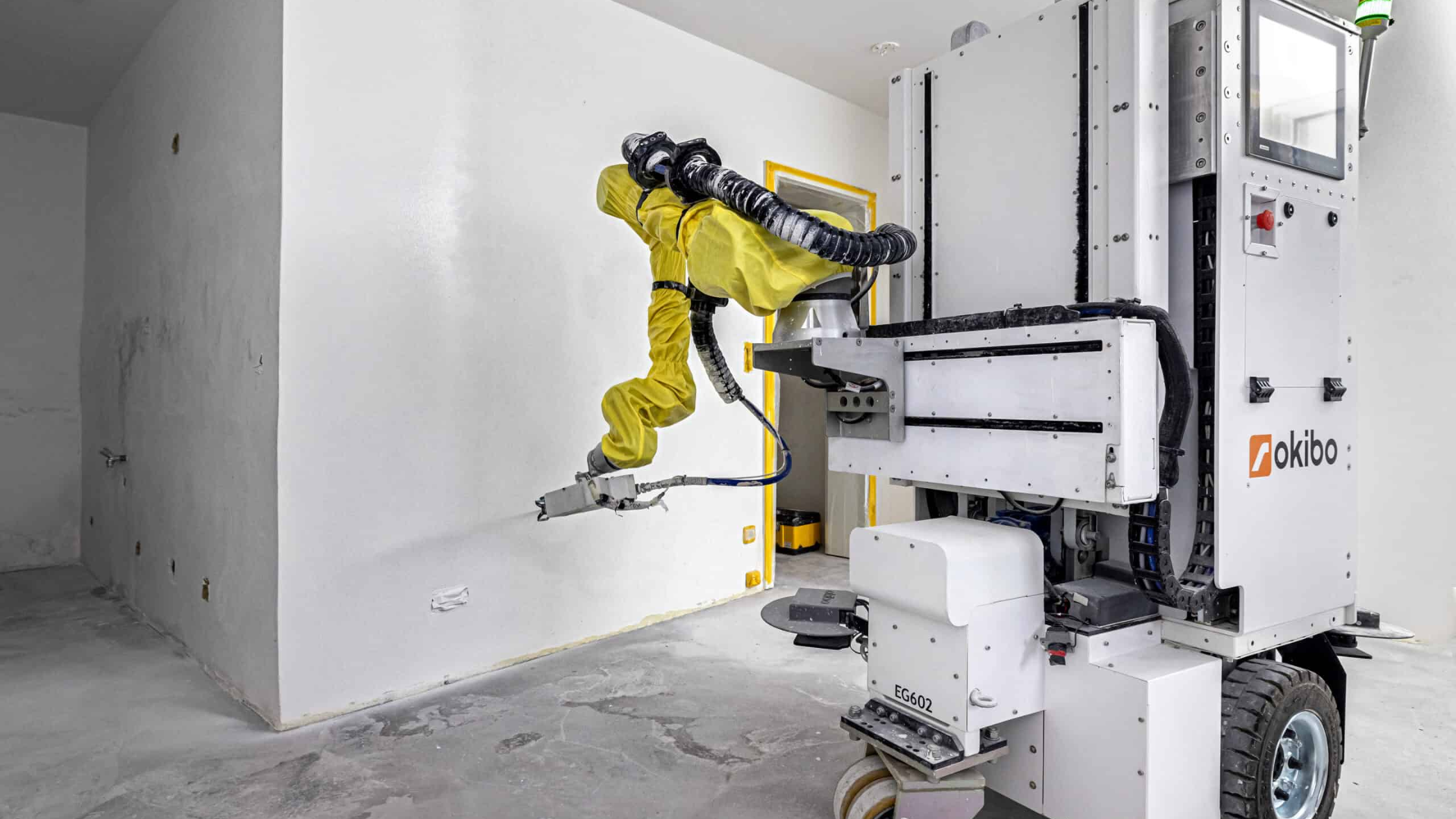 Okibo BLASTER paint gun attached to EG7+ robot spraying wall