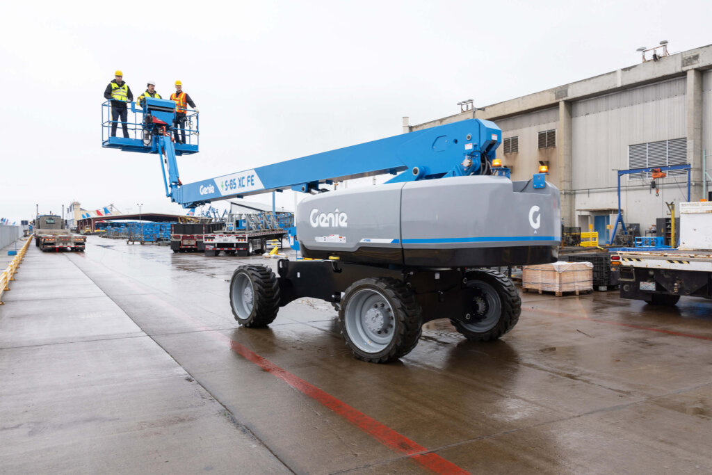 Genie S-85 XC Boom Lift being driven on a work site.