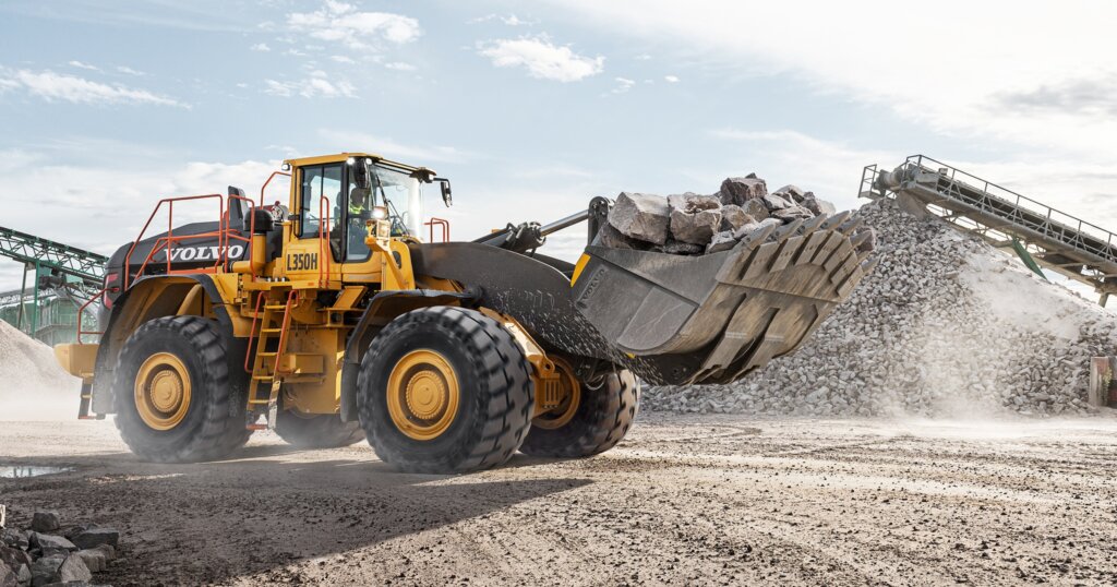 Volvo L350 wheel loader operating in a quarry, moving large volumes of aggregate.