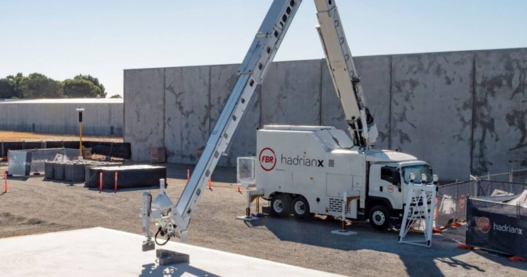 Hadrian X bricklaying robot laying bricks on a construction site.