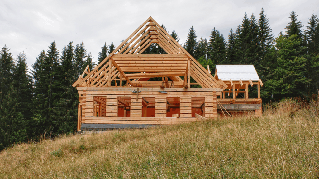 Cabin under construction in wooded area