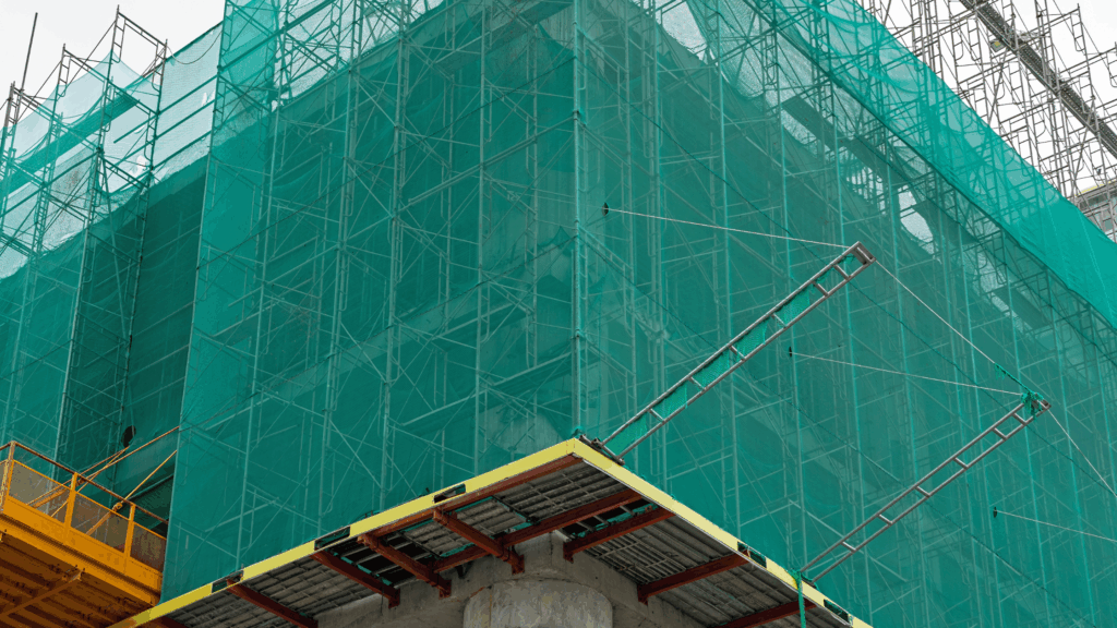 Safety netting around scaffolding helps prevent falling objects and head injuries in construction