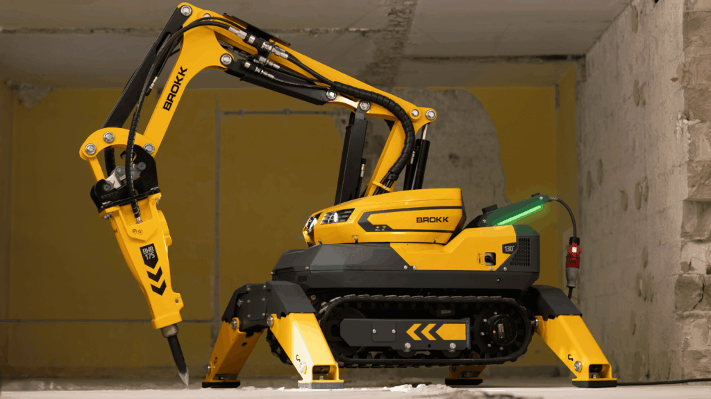 Brokk 130 remote-controlled demolition robot with hydraulic breaker attachment positioned in confined interior demolition space