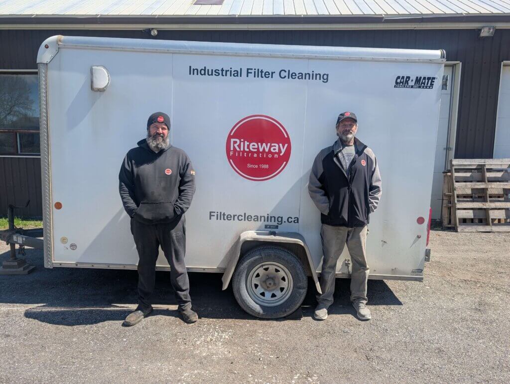 Daniel Maciel and his employee standing in front of a riteway filtration trailer that delivers and cleans air filters for customers.